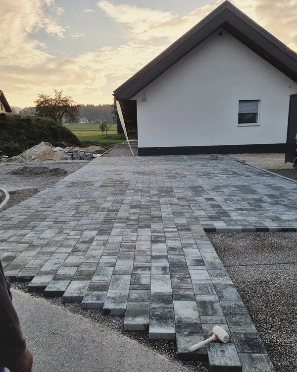 Polaganje tlakovcev na dvorišču pred hišo